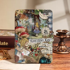 May include: A rectangular decorative item with an Alice in Wonderland collage design. The design includes Alice, mushrooms, clocks, and text that reads "HAVE I GONE MAD?" and "DOWN THE RABBIT HOLE."