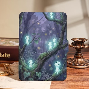 May include: A rectangular e-reader case featuring a dark purple forest scene with mossy tree branches, spiderwebs, and several small, glowing white spirits perched on the limbs. The illustration includes soft yellow light dots scattered throughout.