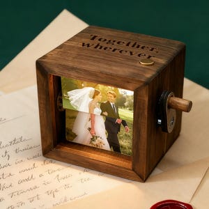 May include: A wooden photo cube with a picture of a couple on their wedding day. The cube has the words "Together, wherever" engraved on top. A small wooden handle is on the side.