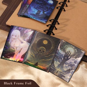May include: A collection of rectangular cards featuring diverse illustrations, including a white-haired fairy, a golden skull with celestial rings, and a hand reaching toward a glowing moon. The cards have a black frame foil finish and are displayed.