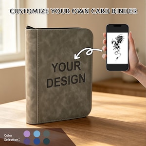 Może przedstawiać: Segregator na karty w kolorze taupe z zapięciem na zamek błyskawiczny i wytłoczonym napisem "YOUR DESIGN" z przodu. Smartfon wyświetla czarną grafikę smoka, a biała strzałka wskazuje z telefonu na segregator. Widoczne są kółka wyboru koloru.