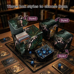 May include: Three rectangular card storage boxes with dark forest graphics and +18 labels, featuring three distinct styles. One box is open, revealing a deck of cards, while a separate small tray contains several blue polyhedral dice.