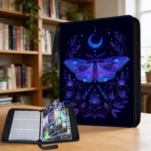 Può includere: Raccoglitore di carte nero con chiusura a zip e manico. La copertina presenta un design a falena e luna crescente blu e viola neon. Un raccoglitore aperto mostra bustine per carte piene.