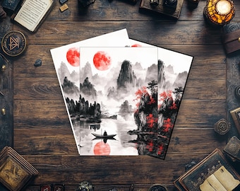 May include: Two art prints depicting a tranquil landscape with a red sun, mountains, and a boat on the water. The artwork uses shades of grey, black, and red, in a traditional Asian style. The prints are displayed on a dark wooden surface.