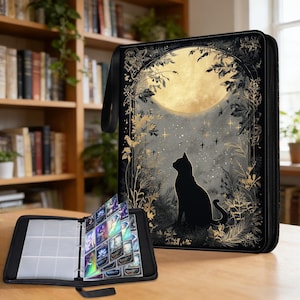 May include: Black card binder featuring a full moon and cat silhouette design. The binder is open, displaying card sleeves filled with colourful cards. The closed binder has a handle and a zip closure. A bookshelf is in the background.