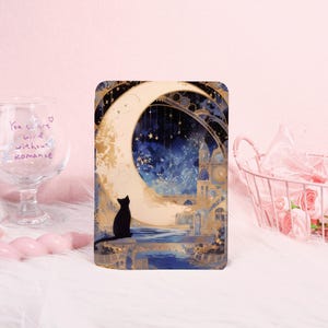 Peut inclure: Impression artistique rectangulaire avec un chat noir devant un croissant de lune et un ciel étoilé. L'œuvre d'art présente un style onirique avec des tons dorés et bleus, évoquant la rêverie.