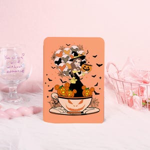 May include: Orange phone case featuring a Halloween-themed design. The design includes a cartoon character in a witch hat holding a jack-o'-lantern, surrounded by bats, Mickey Mouse-shaped balloons, and pumpkin-shaped teacups. The teacup has a jack-o'-lantern face.
