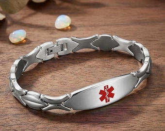 May include: A silver-toned medical alert bracelet featuring a polished metal link band and a central rectangular plate. The plate displays a red Star of Life symbol, which consists of a six-pointed star with a white serpent and staff emblem.