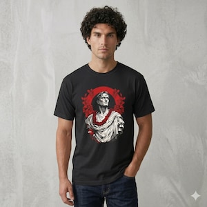 May include: Black t-shirt featuring a graphic of a classical bust with a red floral wreath and a red circle behind the bust. The bust is white and the wreath is red. The t-shirt is short-sleeved and has a crew neck.