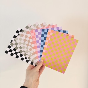 Könnte beinhalten: Ein Satz von zehn Karten mit Schachbrettmuster in verschiedenen Farben, darunter Schwarzweiß, Grauweiß, Rosaweiß, Lilaweiß, Blauweiß, Gelbrosa und Orange-Rosa.