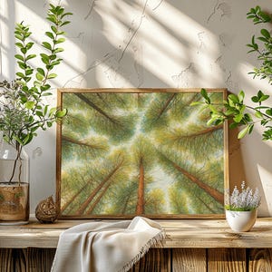 以下が含まれることがあります： 額装されたアートプリントは、森のキャノピーを通して見上げる様子を描いています。アートワークは、緑の葉と茶色の幹を持つ高い木々を、薄い青色の空を背景に特徴としています。プリントは、装飾的な植物のある木製の表面に表示されます。