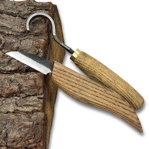 May include: Two wood carving knives with wooden handles and metal blades. One knife has a curved blade, and the other has a straight blade. The handles are made of light brown wood, and the blades are silver.