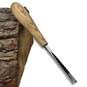 May include: A wood carving gouge with a light brown wooden handle and a silver blade. The handle has a natural wood grain pattern. The blade is angled and appears sharp. The tool is designed for woodworking and carving.
