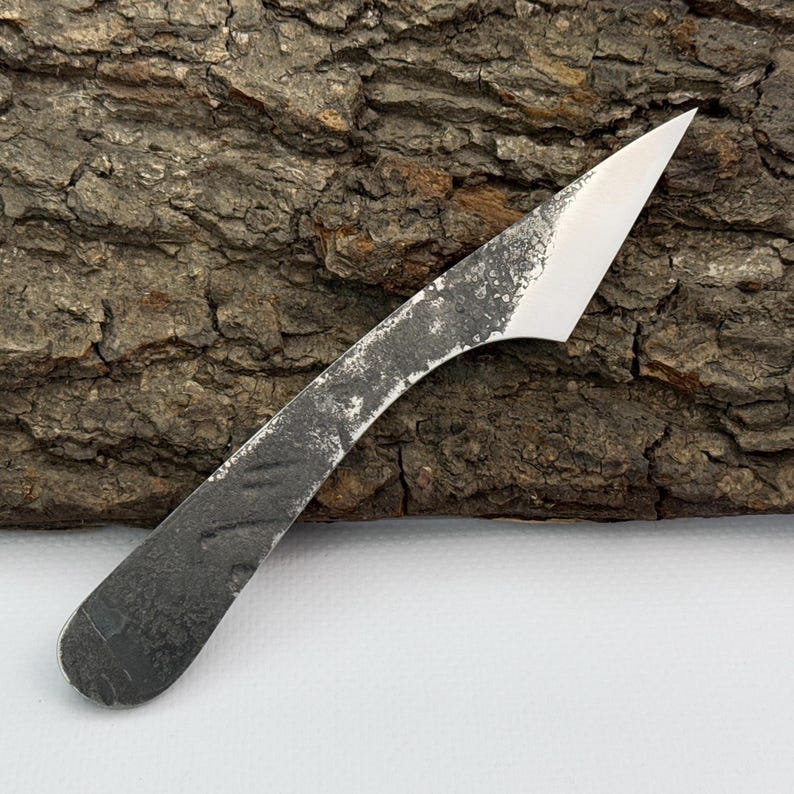 Hand-forged kiridashi on bark, compact Japanese utility blade for carving and marking.
