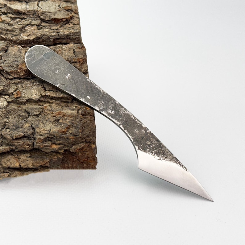 Kiridashi against bark, edge down - compact pocket carving and utility blade.