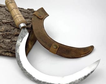 Handgesmede grote tuinsikkel: koolstofstalen mes, ergonomisch essenhandvat, leren schede, handzeis voor oogsten en borstelen.