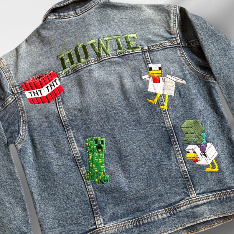 May include: A blue denim jacket with embroidered patches featuring Minecraft characters, including a creeper, a chicken, and a zombie holding a chicken. The name "HOWIE" is embroidered in green on the back of the jacket.