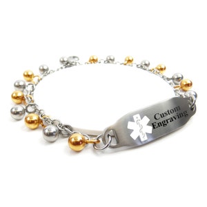 May include: A silver and gold medical ID bracelet with a charm chain and a rectangular tag that says "Custom Engraving" with a medical symbol.