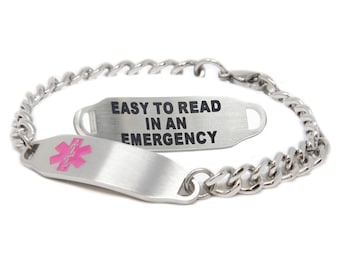 Puede incluir: Un brazalete de identificación médica de plata con una banda de eslabones de cadena y una etiqueta rectangular que dice "EASY TO READ IN AN EMERGENCY". La etiqueta tiene un símbolo médico rosa.