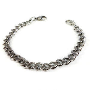 May include: A silver curb chain bracelet with a lobster clasp.