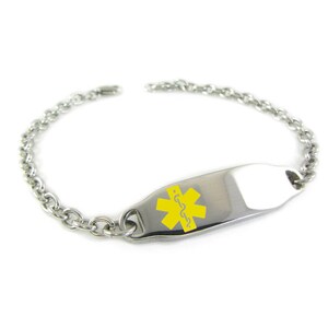 May include: A silver chain bracelet with a yellow medical alert tag. The tag has a star of life symbol and the word "diabetes" written in cursive.