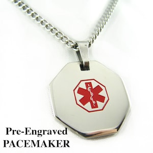 May include: A silver chain necklace with a silver octagon-shaped pendant. The pendant has a red medical symbol with a snake and staff. The pendant is pre-engraved with the word "PACEMAKER".