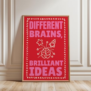 May include: A rectangular framed wall art print featuring a vibrant red background with a white dashed border. The text reads DIFFERENT BRAINS, BRILLIANT IDEAS in bold pink letters. A white line drawing of a brain, a star, and a rocket ship.