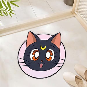Alfombra de poliéster con diseño de gato negro, inspirada en el anime, con luna creciente y detalles en rosa pastel para una decoración acogedora.