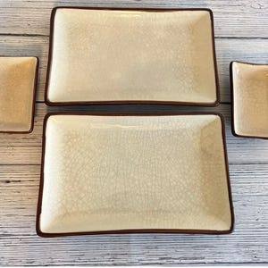May include: A set of four ceramic serving dishes. Two large rectangular plates and two smaller rectangular dishes. The plates are off-white with a crackle glaze and a dark brown border. Ideal for serving appetizers or sushi.