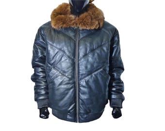 May include: A black leather bomber jacket with a brown fur collar. The jacket has a zip-up front, ribbed cuffs, and a ribbed hem. The leather is quilted with a chevron pattern. A stylish outerwear piece.