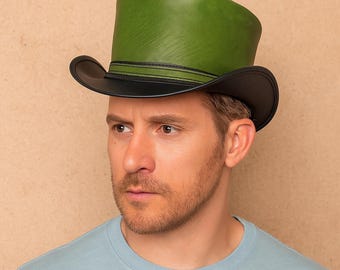 Puede incluir: Un sombrero de copa verde con ala negra y una banda negra. El sombrero está hecho de un material liso y tiene una forma clásica de sombrero de copa. El sombrero lo lleva una persona.