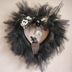Coroa gótica em formato de coração negro, decoração com laço de esqueleto.