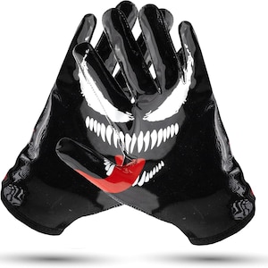 May include: Black and red football gloves with a white Venom graphic. The gloves have a textured surface and a black and red design.
