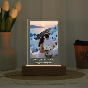 Könnte beinhalten: Ein beleuchteter Acryl-Fotorahmen mit Holzsockel. Der Rahmen zeigt ein Paar, das eine Küstenstadt bei Sonnenuntergang überblickt. Der Text auf dem Rahmen lautet: "She's my lobster - I know we'll grow old together."