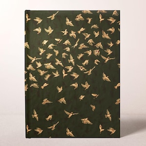 May include: A dark green journal with a flock of gold-colored birds in flight. The birds are scattered across the cover, creating a sense of movement and freedom. The journal has a simple, elegant design.