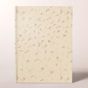 May include: A hardcover journal with a cream-colored cover adorned with a pattern of flying birds in shades of beige and brown. The birds are scattered across the cover, creating a sense of movement and freedom. The journal is rectangular.