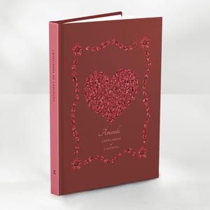 May include: A maroon hardcover book titled "Loveliness of Ladybugs." The cover features a heart design made of red gems, framed by a gem-studded border. The name "Amanda" is below the heart.
