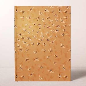 May include: A hardcover journal with a repeating pattern of birds in flight against a warm, golden-brown background. The birds are depicted in various poses, creating a sense of movement and freedom. The journal is rectangular.