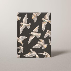 May include: A rectangular notebook with a black cover featuring a pattern of white and gray birds in flight. The birds have detailed wings and are set against a dark background, creating a striking contrast.