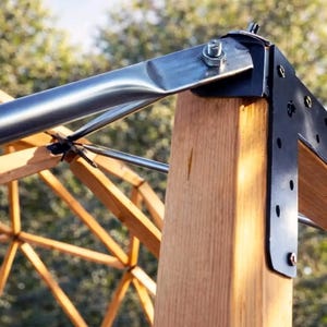 May include: Close-up of a wooden structure with metal brackets and supports. The image shows a combination of natural wood and metallic elements, with a focus on the structural details and joinery. The text "ARCH. BOGD." is visible at the bottom.