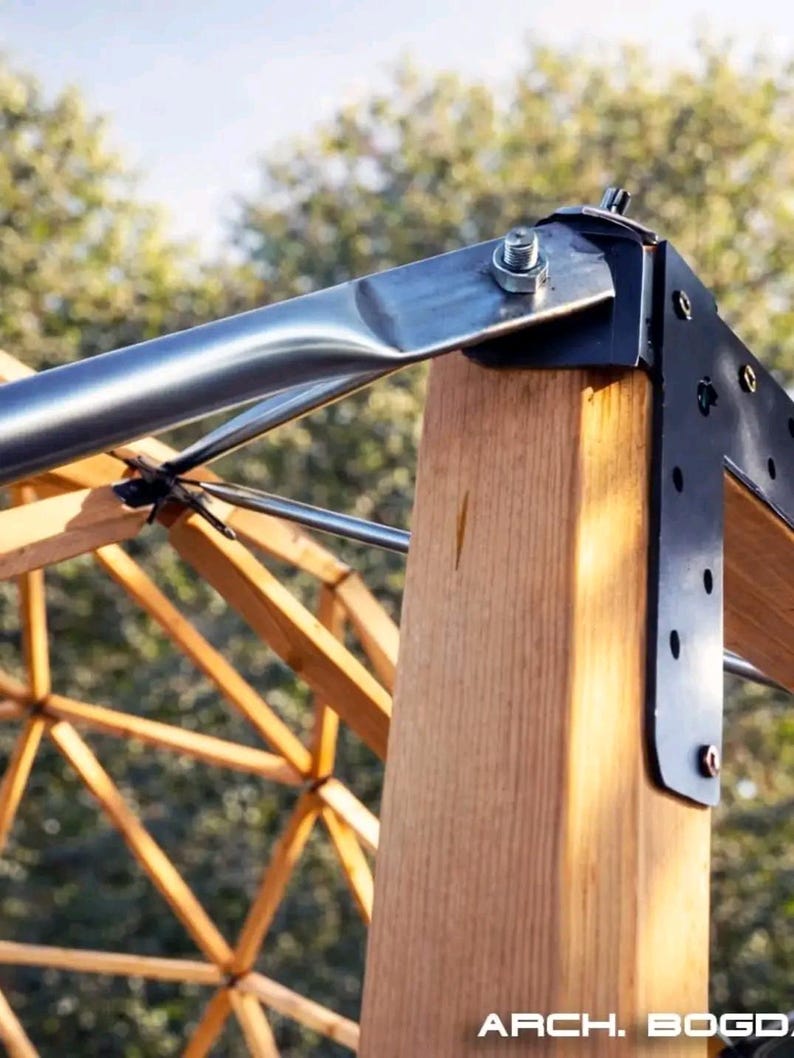 May include: Close-up of a wooden structure with metal brackets and supports. The image shows a combination of natural wood and metallic elements, with a focus on the structural details and joinery. The text "ARCH. BOGD." is visible at the bottom.