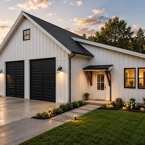 Op de afbeelding: Een wit huis met verticale gevelbekleding en een zwart metalen dak, voorzien van twee zwarte garagedeuren, een entree met een houten luifel en ramen met zwarte kozijnen. De buitenkant is verlicht door wandlampen en tuinverlichting.