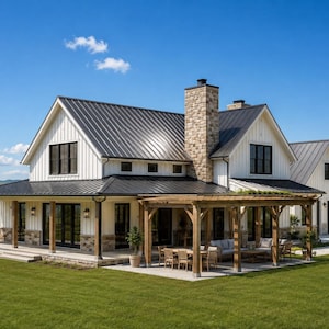 May include: A two-story farmhouse with white vertical siding, a dark metal roof, and a stone chimney. The exterior features a wrap-around porch and a wooden pergola covering a patio area with outdoor furniture, set against a green lawn.