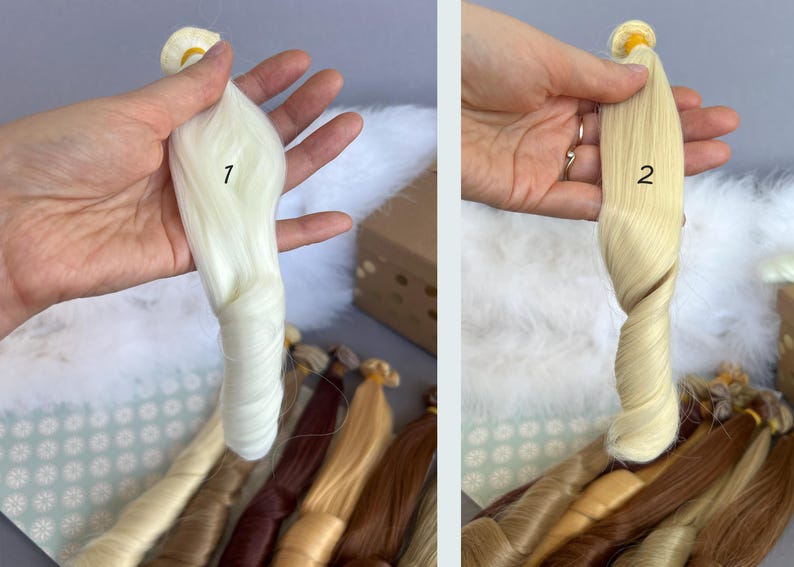 May include: Two bundles of doll hair in shades of white and blonde are held up for display. The hair is styled in a twisted, wavy pattern. Other bundles of hair in various shades of brown and blonde are visible in the background.
