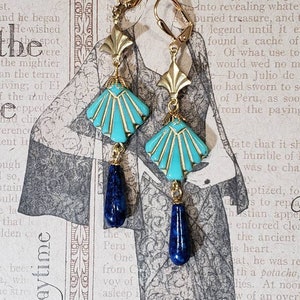 May include: A pair of drop earrings featuring gold-tone lever back hooks, a gold-tone fan-shaped metal component, a turquoise-coloured fan-shaped glass bead with gold-tone inlay, and a dark blue teardrop-shaped stone bead at the bottom.