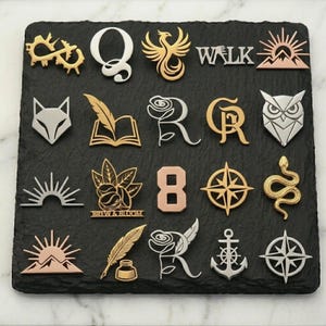 May include: A collection of various metal pins and charms in gold, silver, and copper tones. Designs include a fox, owl, compass, phoenix, rose, anchor, and the word "WALK". The pins are arranged on a dark, textured surface.