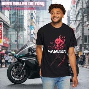 May include: Black t-shirt with a red and white graphic of a samurai mask and the word "SAMURAI". The image also includes a black motorcycle and the text "BEST SELLER ON ETSY" and "RATED 5 STARS BY GEEKS".