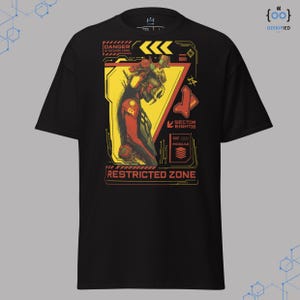 May include: Black t-shirt with a graphic design featuring a futuristic figure in red, yellow, and black. The design includes the text "DANGER ALHAZARD ZONE" and "RESTRICTED ZONE". The shirt also has the text "SECTOR EIGHT08" and "DE MODULE".