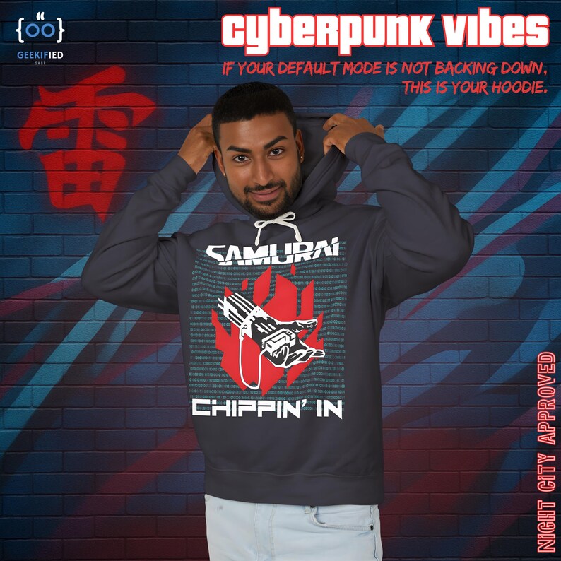 Op de afbeelding: Donkergrijze hoodie met de tekst "SAMURAI CHIPPIN' IN" en een rode afbeelding van een hand die een apparaat vasthoudt. De hoodie heeft ook de tekst "cyberpunk vibes" en "IF YOUR DEFAULT MODE IS NOT BACKING DOWN, THIS IS YOUR HOODIE."