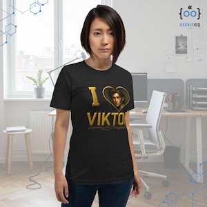 May include: A black t-shirt with a gold graphic of a heart with a character's face inside and the text "I love Viktor" underneath.